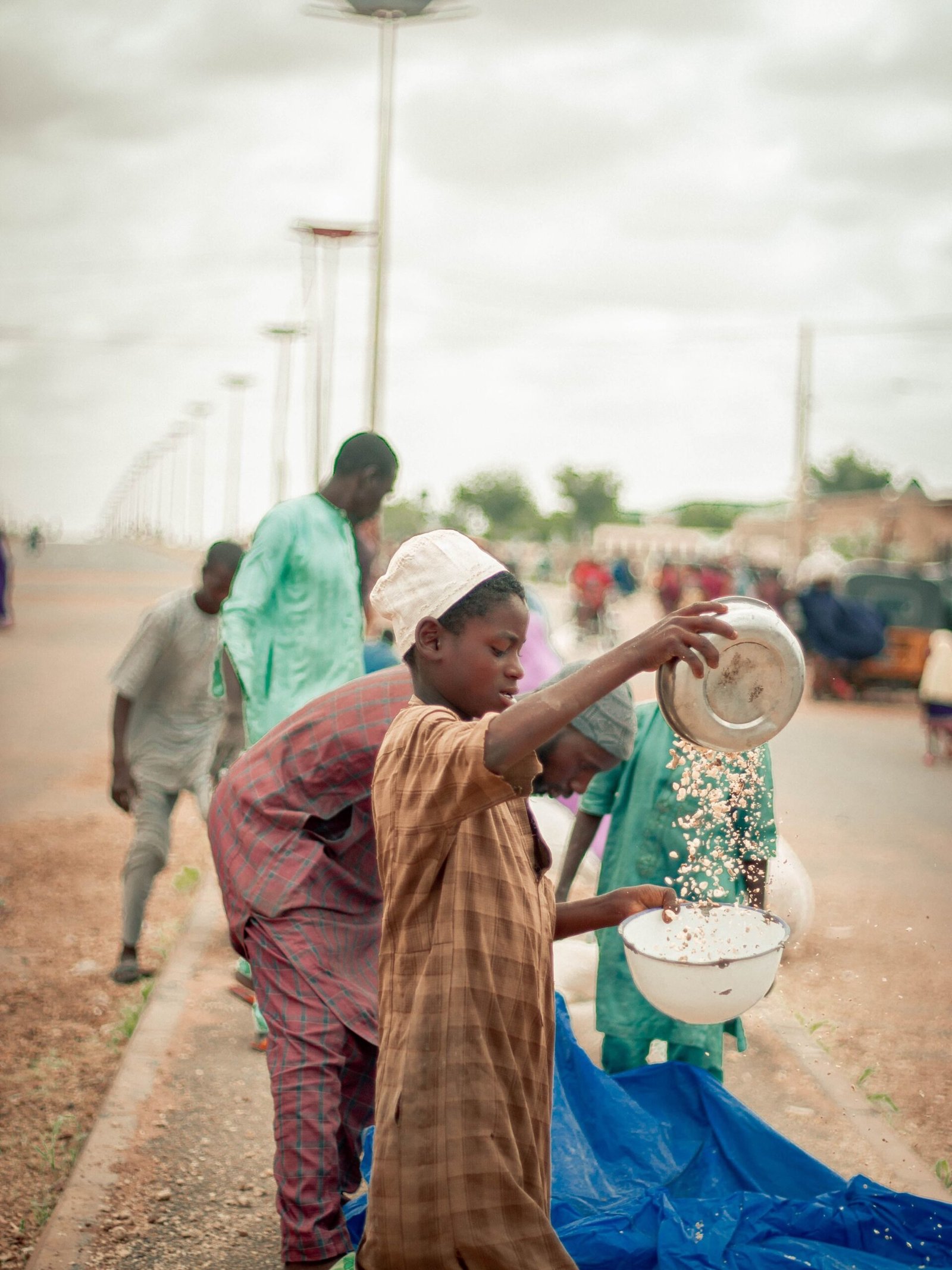 Men engaged in daily activities on a street in Africa, showcasing vibrant cultural attire.